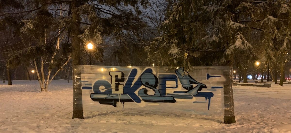 snow covered bench near trees during daytime